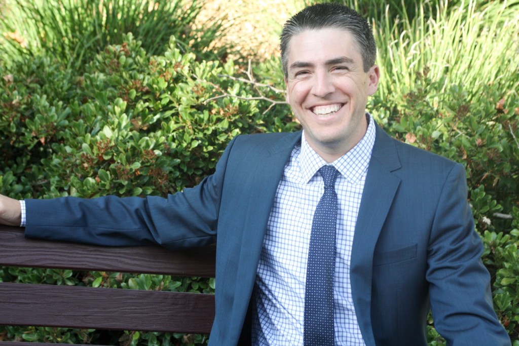 A man in suit and tie sitting on a bench.