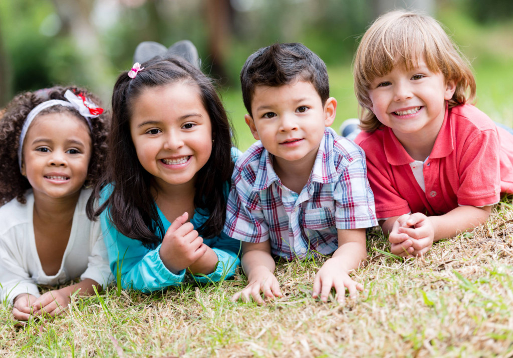 A group of children laying in the grass.