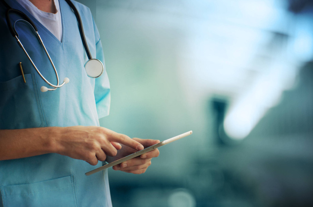 A doctor is using his tablet computer.