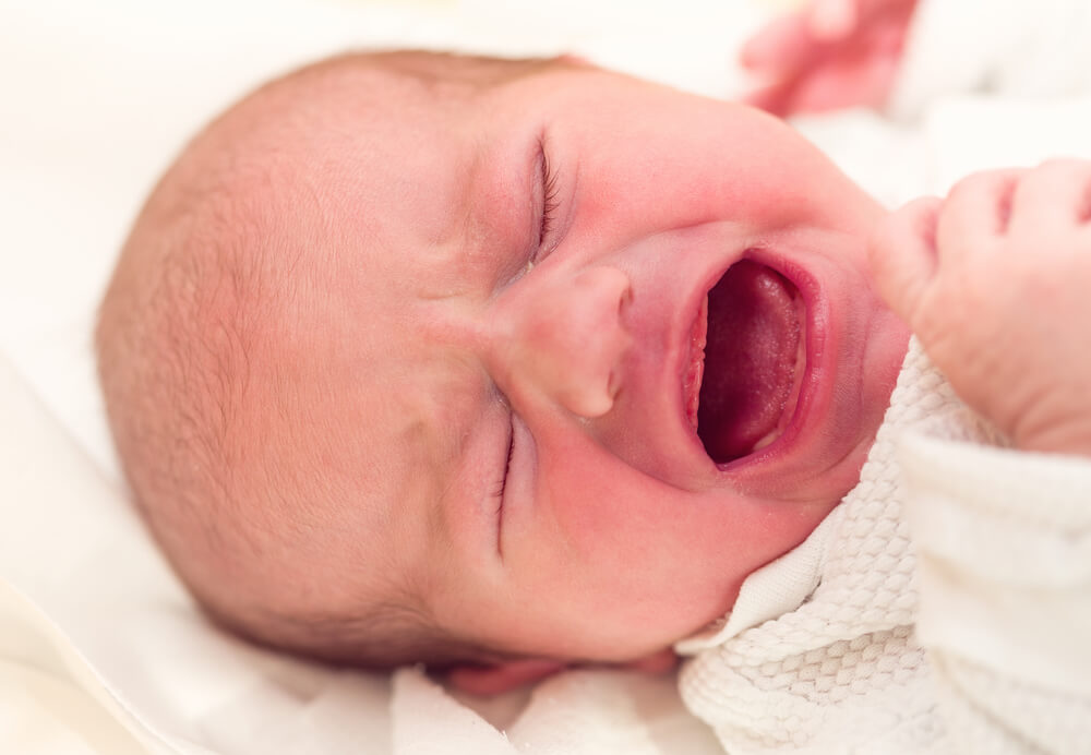 A baby is crying while laying down.