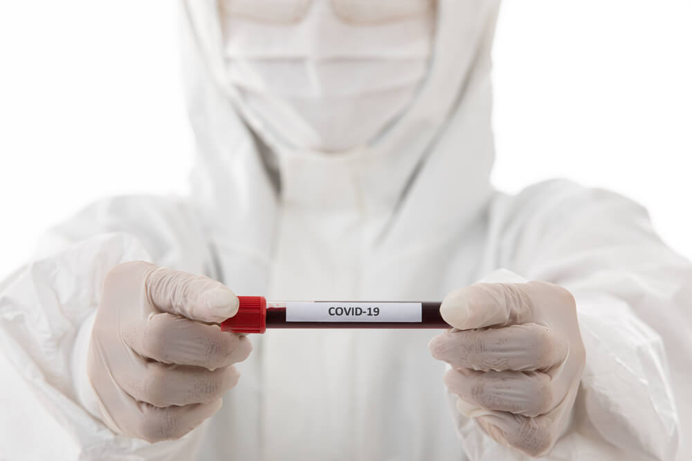 Healthcare worker in PPE presenting COVID-19 sample