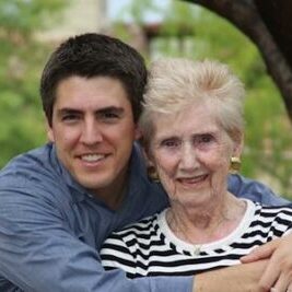 A man and woman are hugging outside.